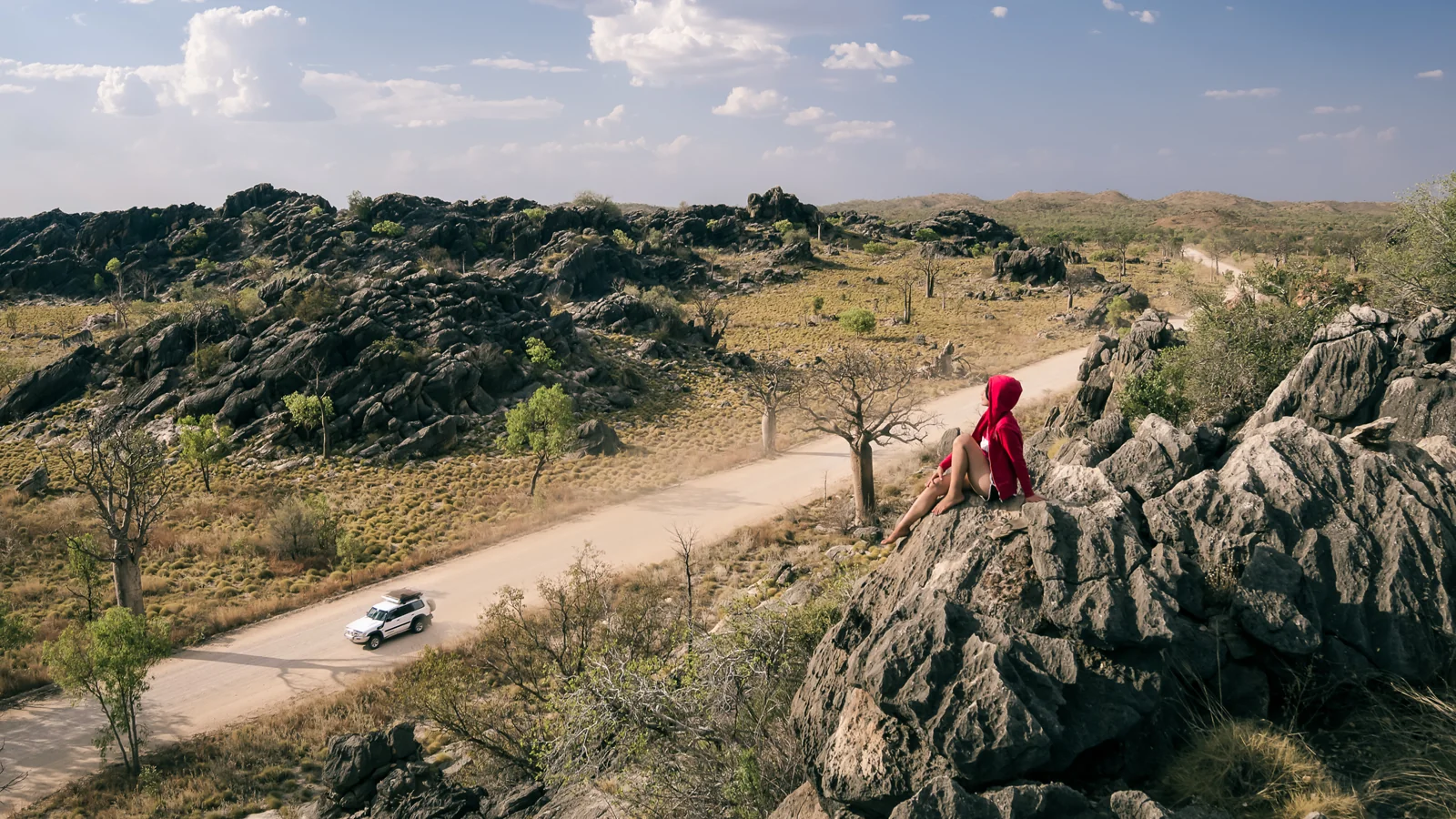 Person overlooking a road from a rocky outcrop