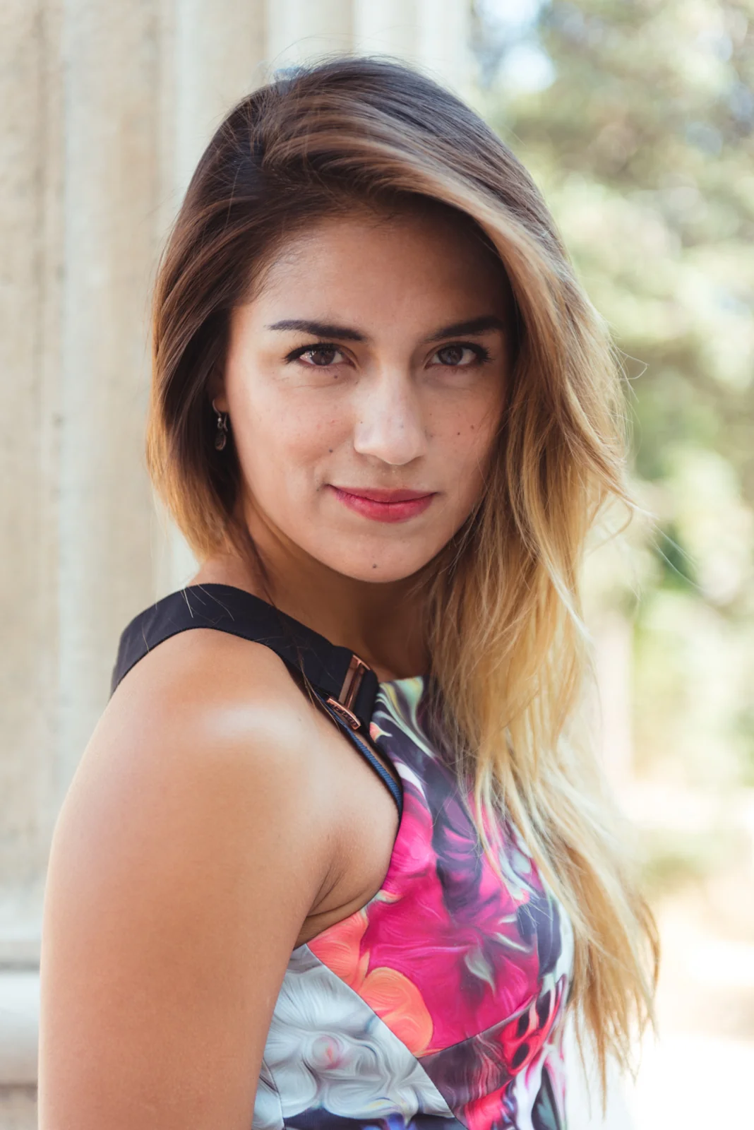 Portrait of a woman in a floral dress outdoors.