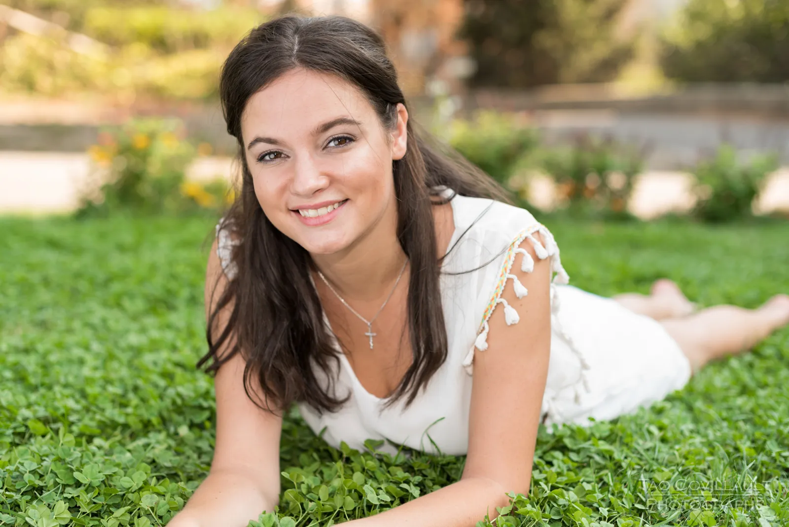 Woman in a white dress relaxing on grass.