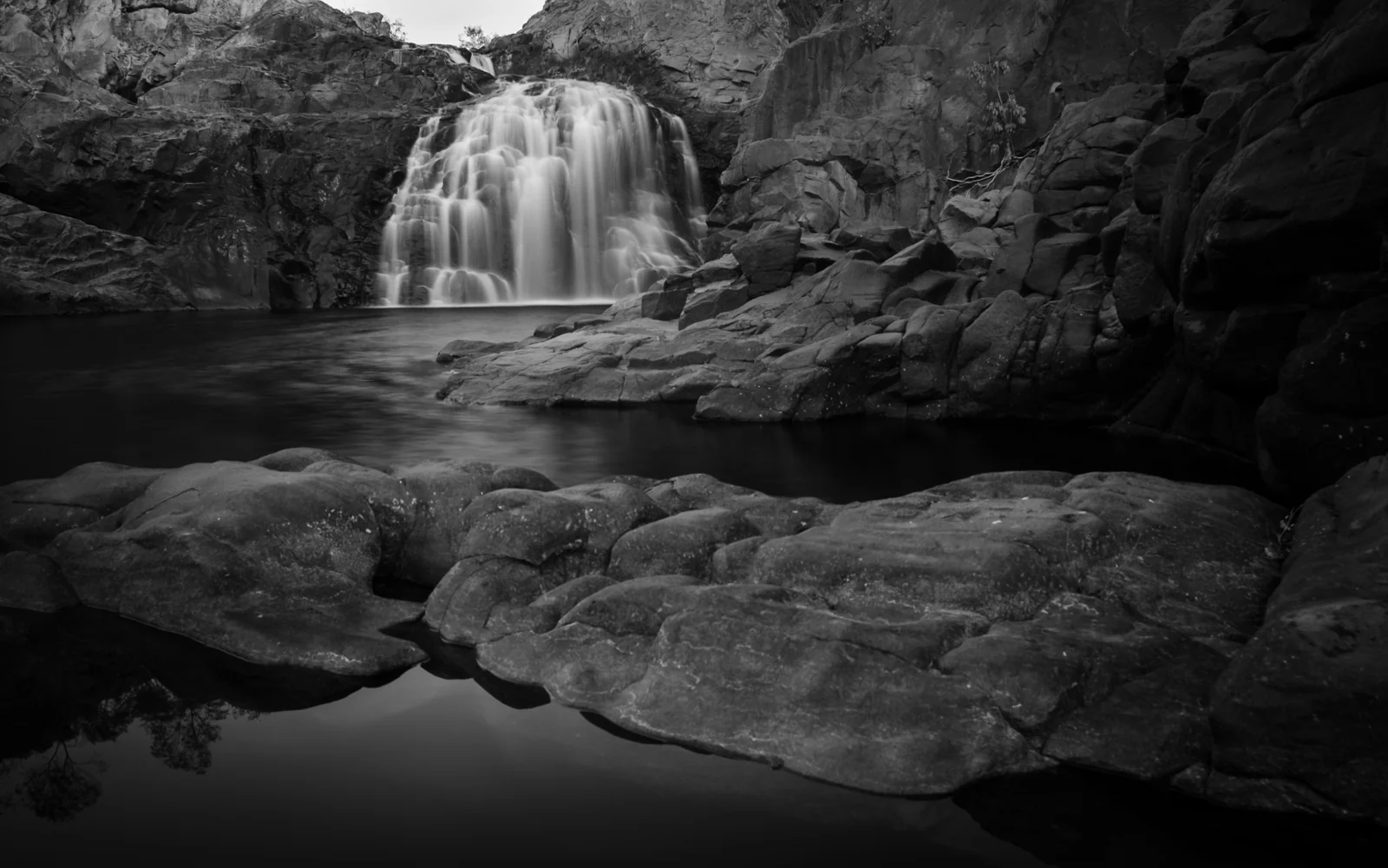 Waterfall cascading between rocks in black and white