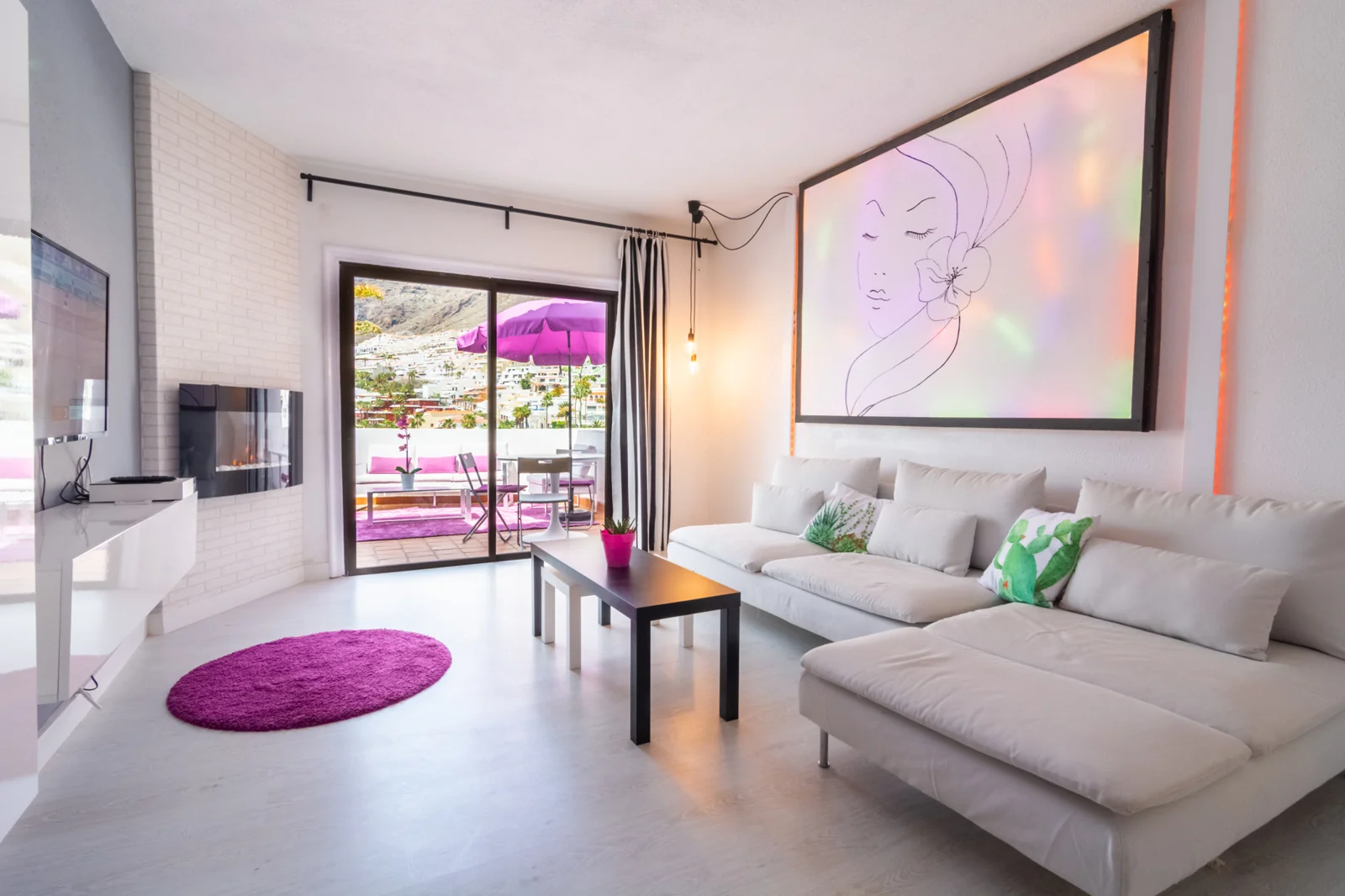 Modern living room with white seating and magenta accents.