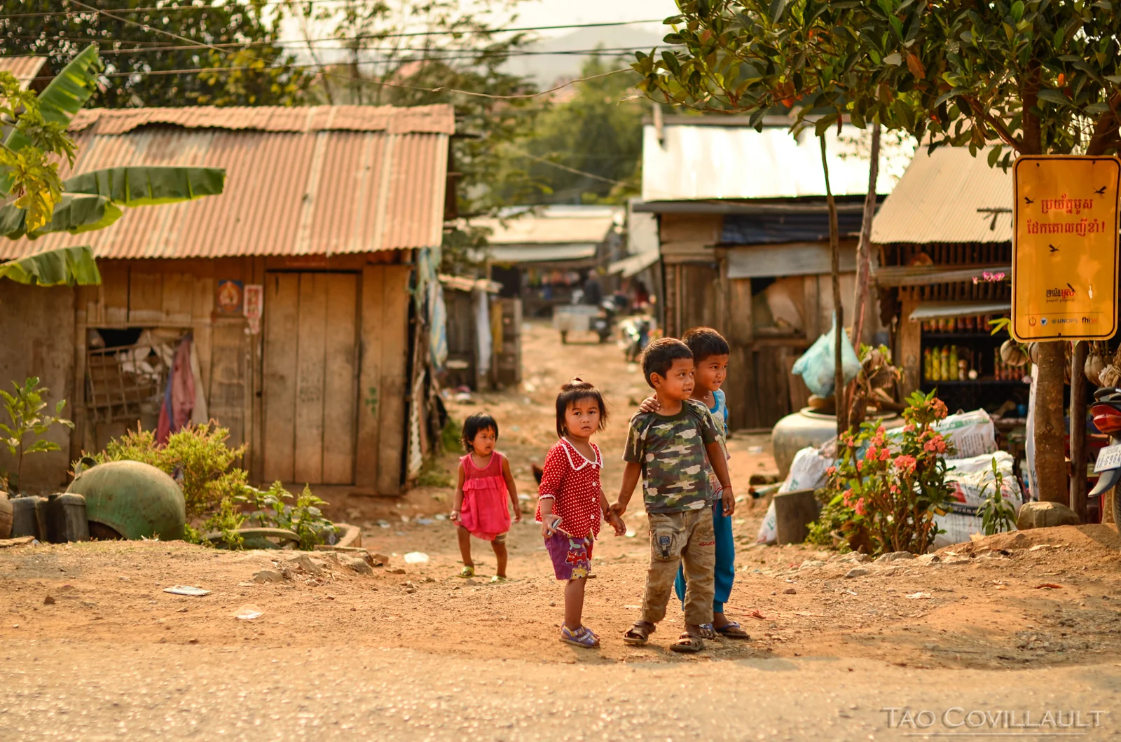 Children standing along a dusty village street