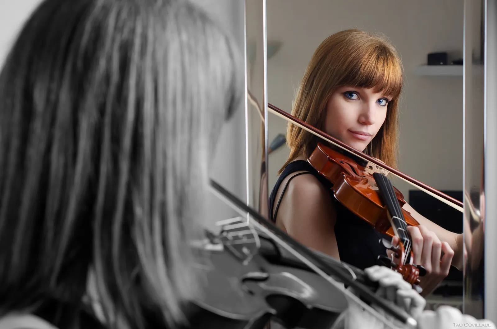 Woman playing a violin in front of a wooden wall.