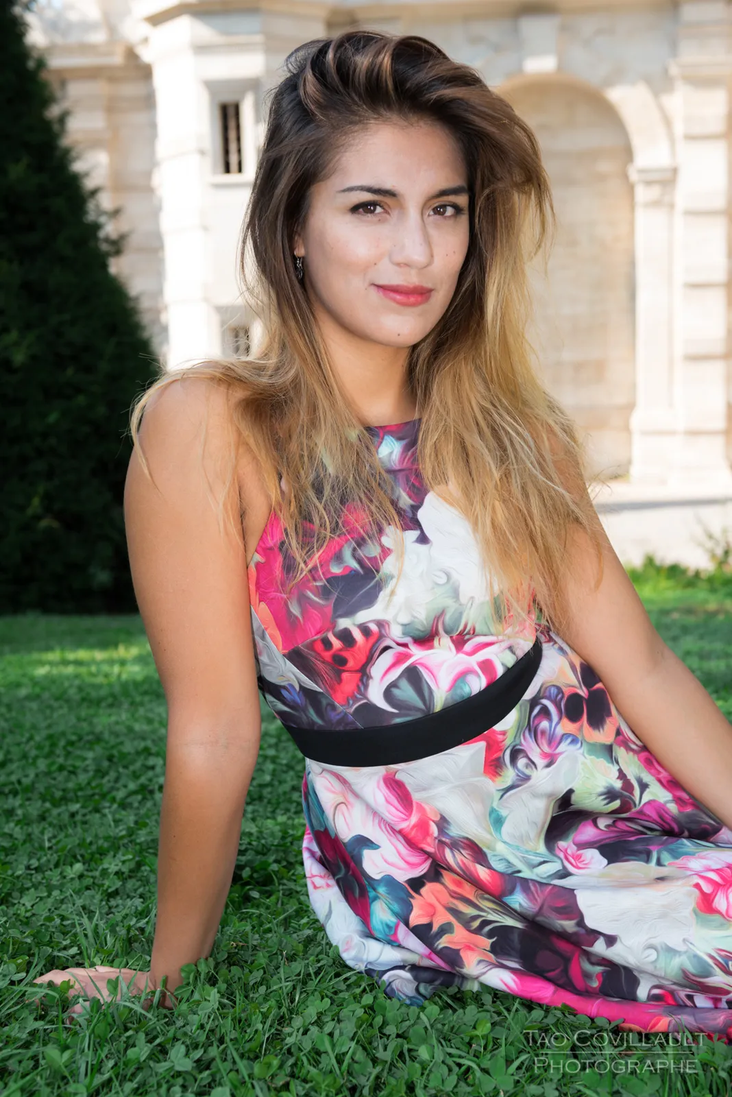 Portrait of a woman in a floral dress outdoors.