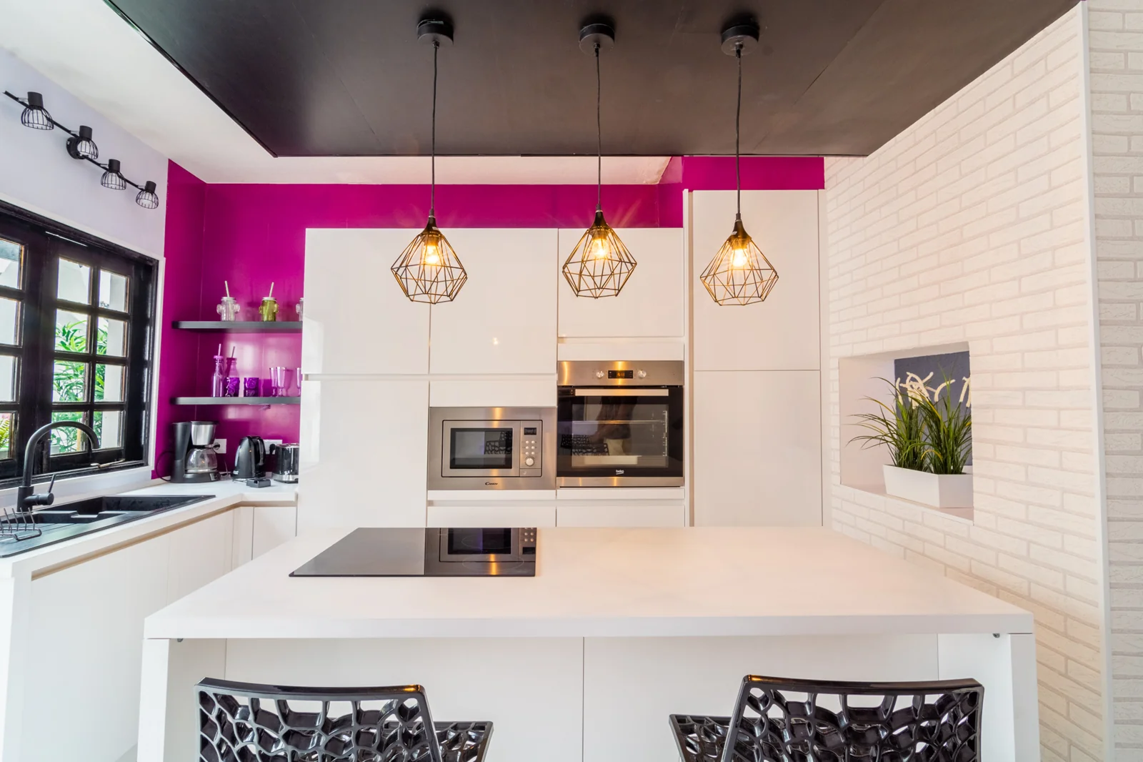 White kitchen with geometric pendant lamps.