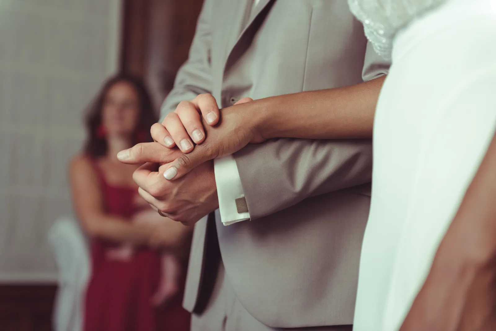 Close-up of hands during the exchange of wedding rings.