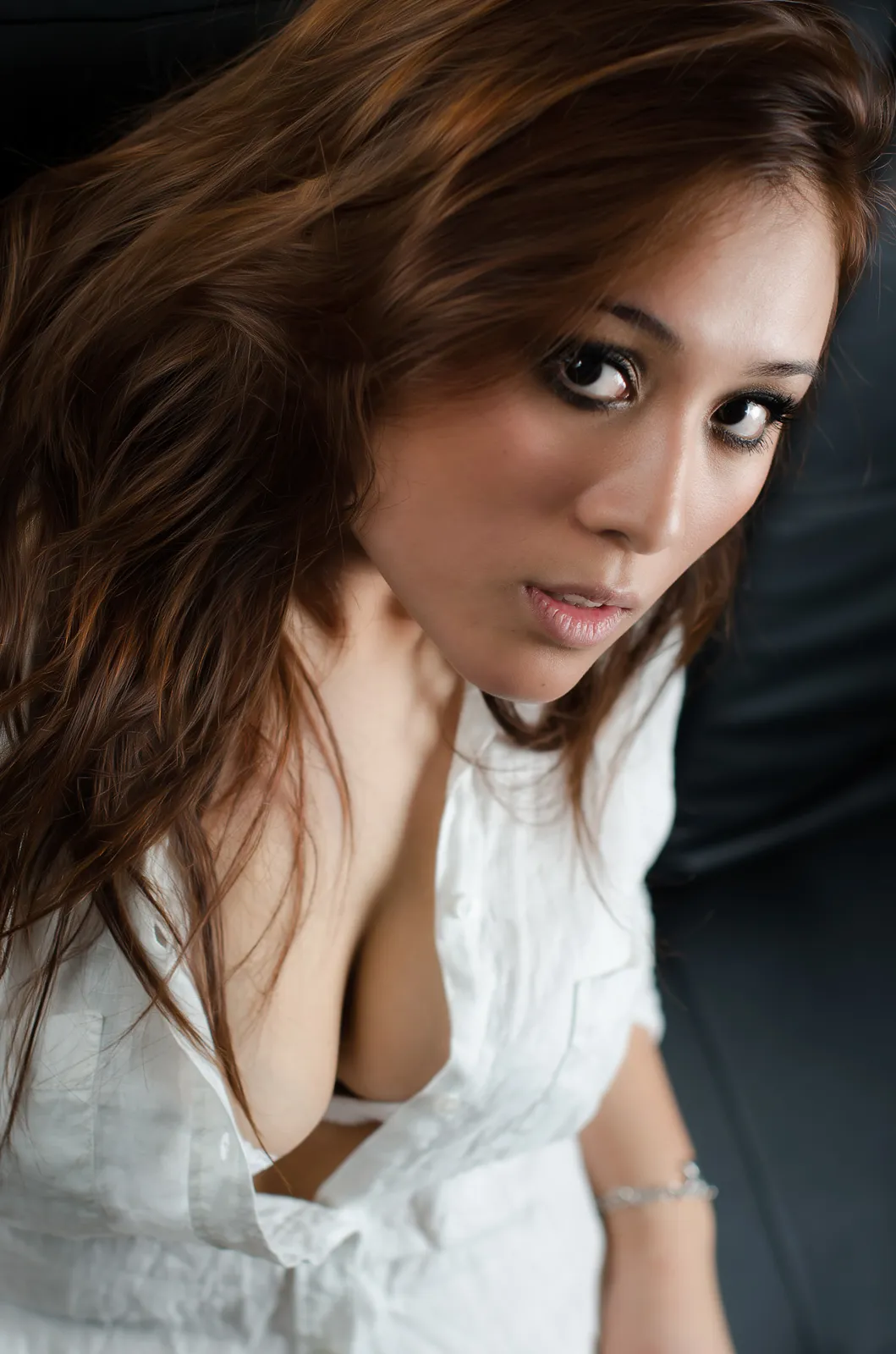 Woman in a white shirt looking toward the camera indoors.