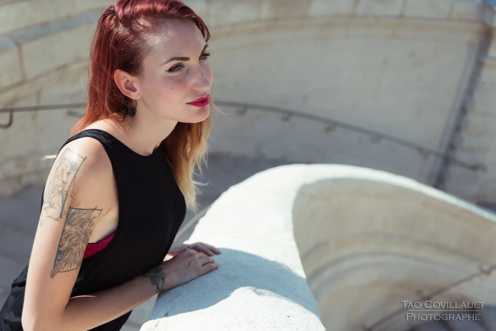 Woman in black clothing posing on pale stone steps.