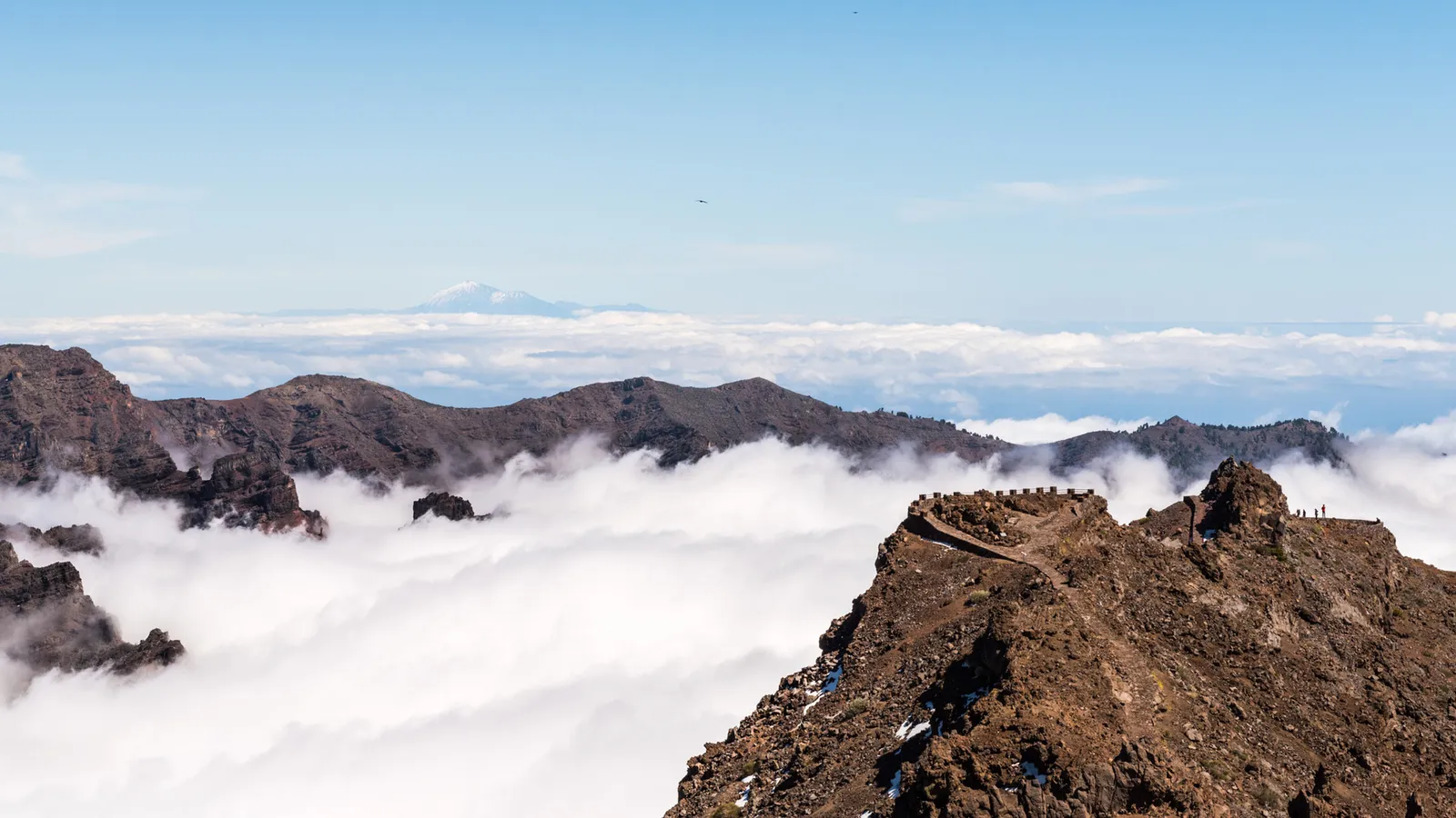 Volcanic-looking mountain ridges emerging through clouds