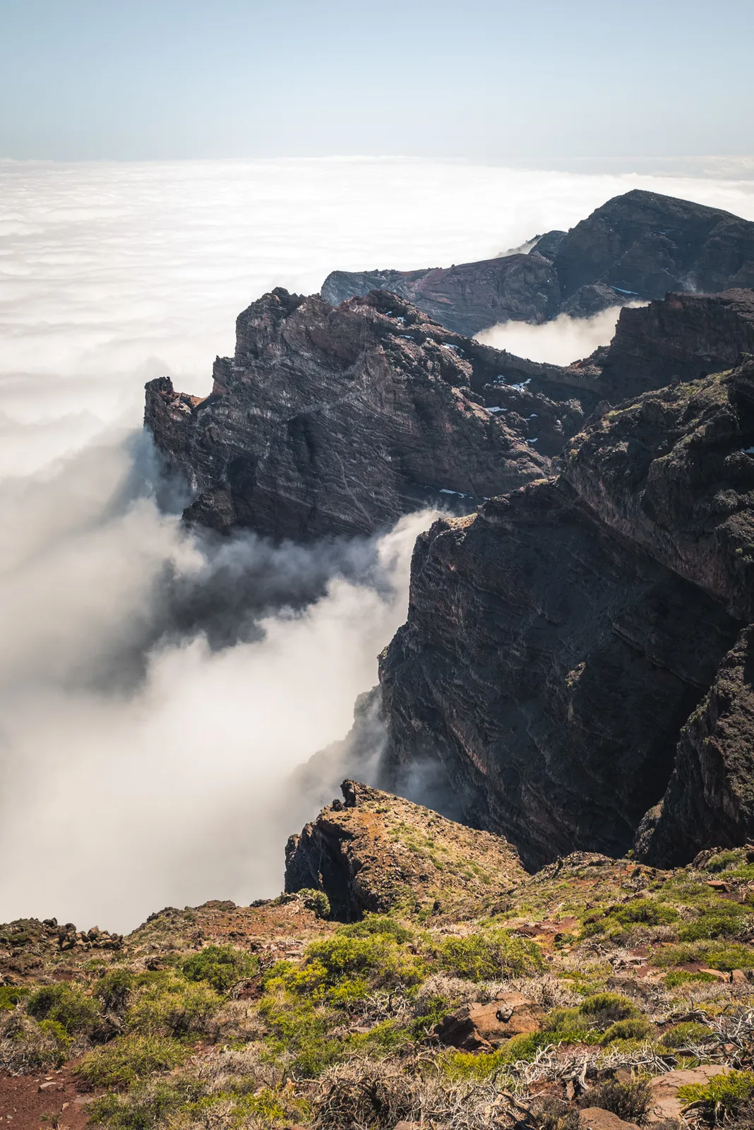 Jagged mountain ridge rising above clouds