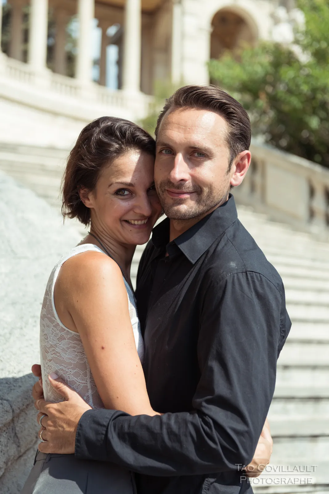 Couple embracing beside a stone balustrade.
