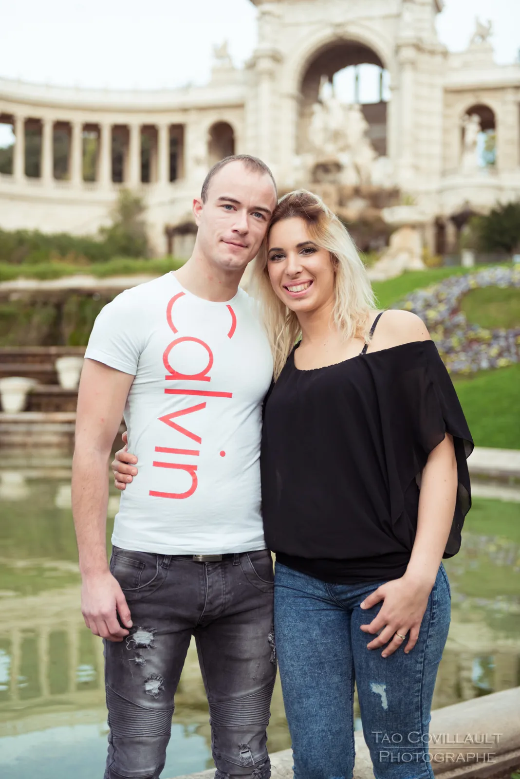 Couple standing together in front of an ornate building.