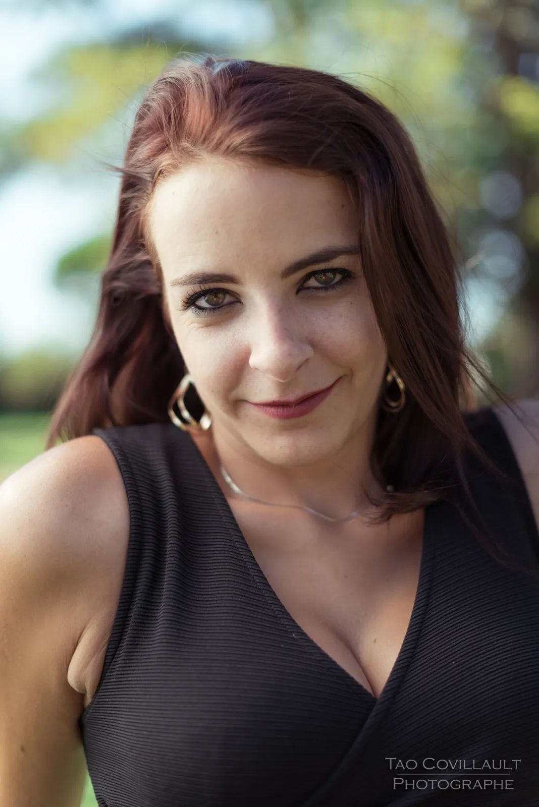 Close-up portrait of a woman in a black dress.