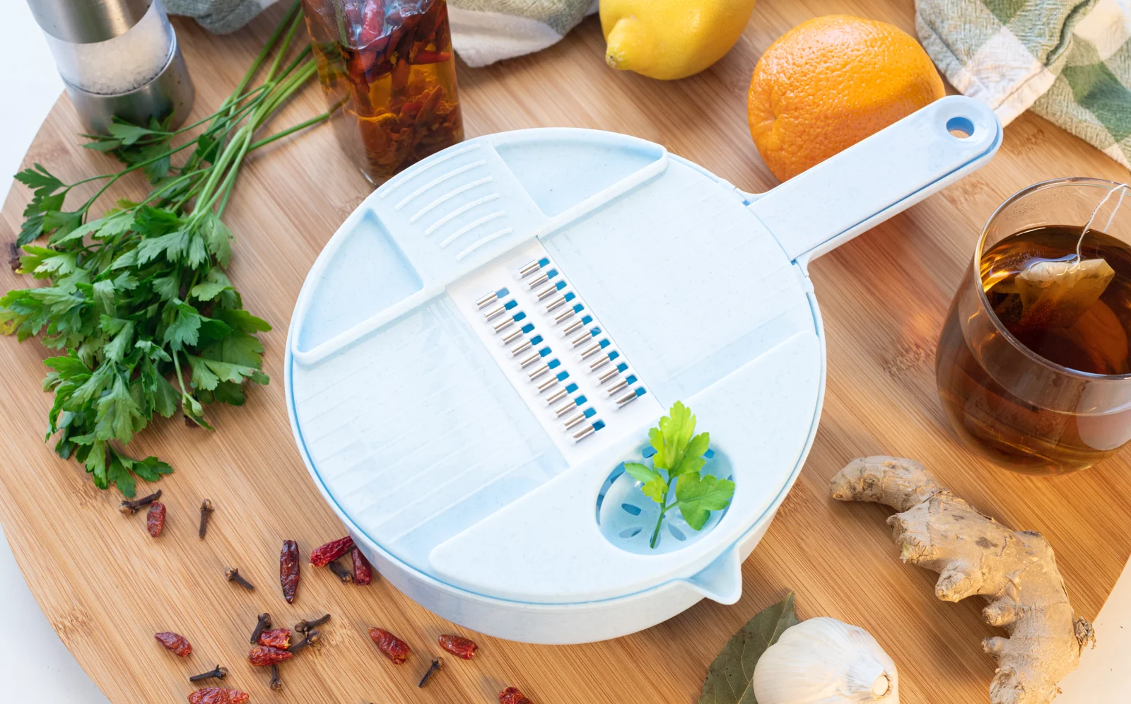 Kitchen grater arranged with herbs and citrus.