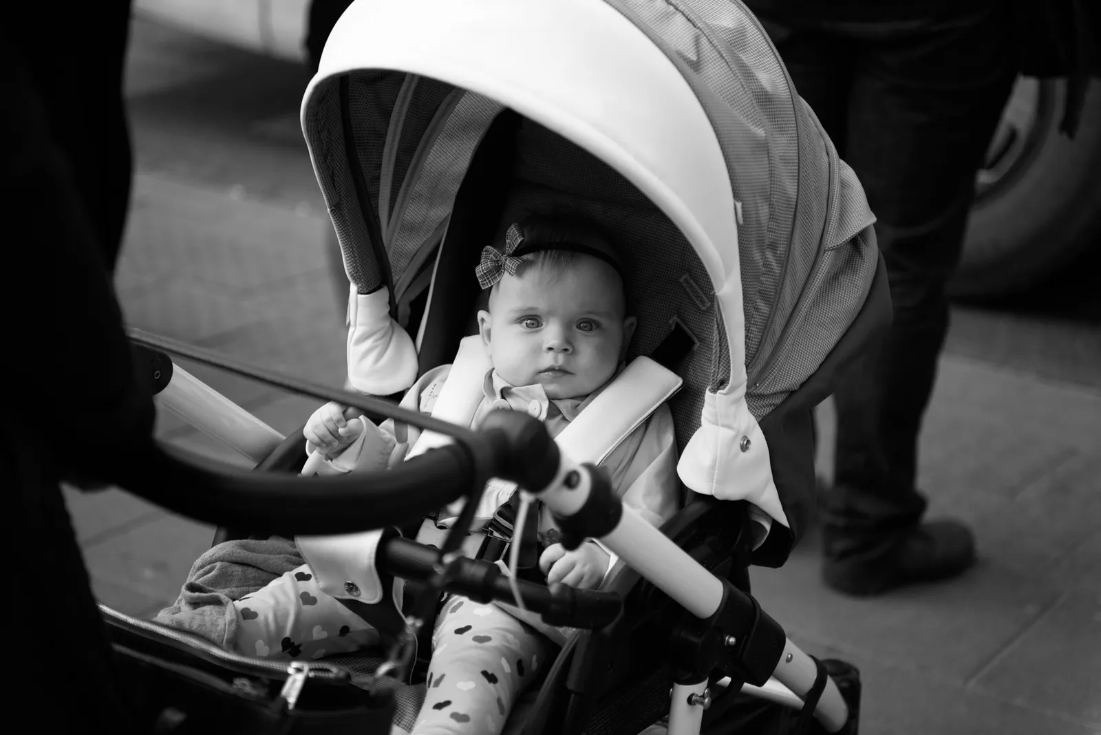 Baby seated in a stroller in black and white