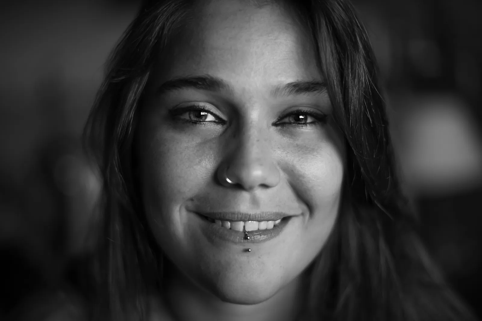 Black-and-white photograph: smiling woman in a close-up portrait.
