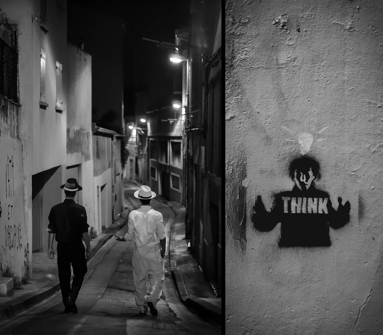 Two people walking down a narrow graffiti-lined alley in black and white
