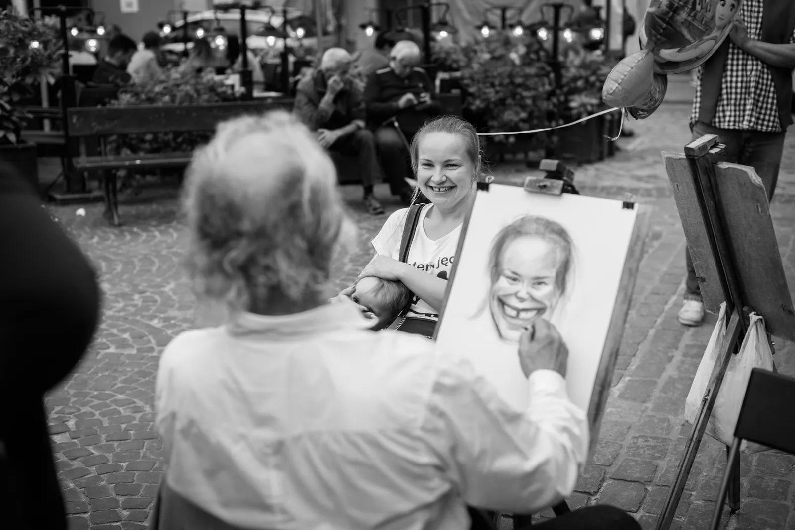 Street artist drawing a smiling sitter in black and white