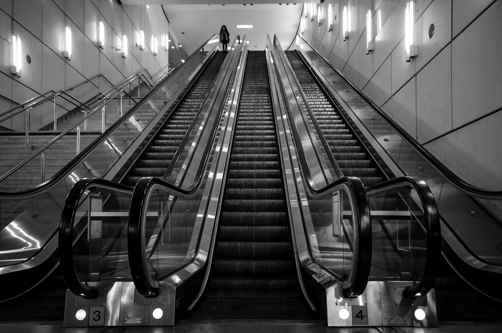 Symmetrical view of station escalators in black and white