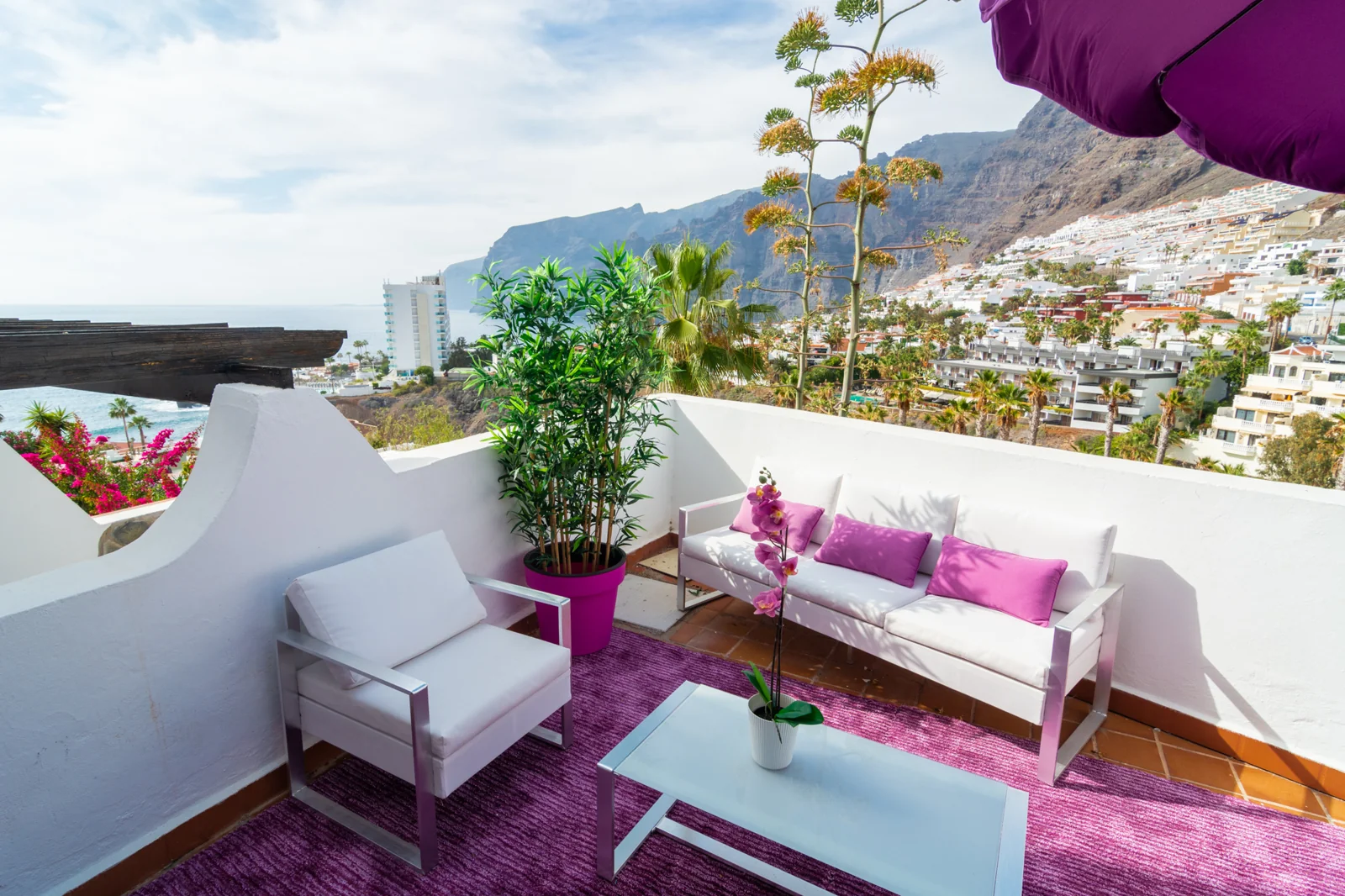 Sunny terrace overlooking a mountain landscape.