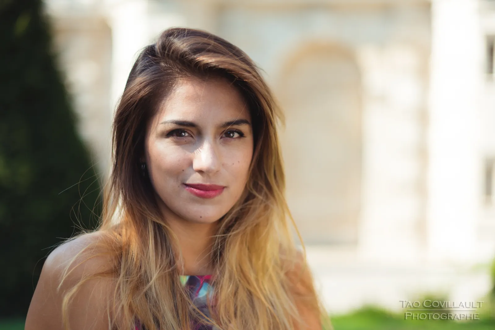 Portrait of a woman in a floral dress outdoors.