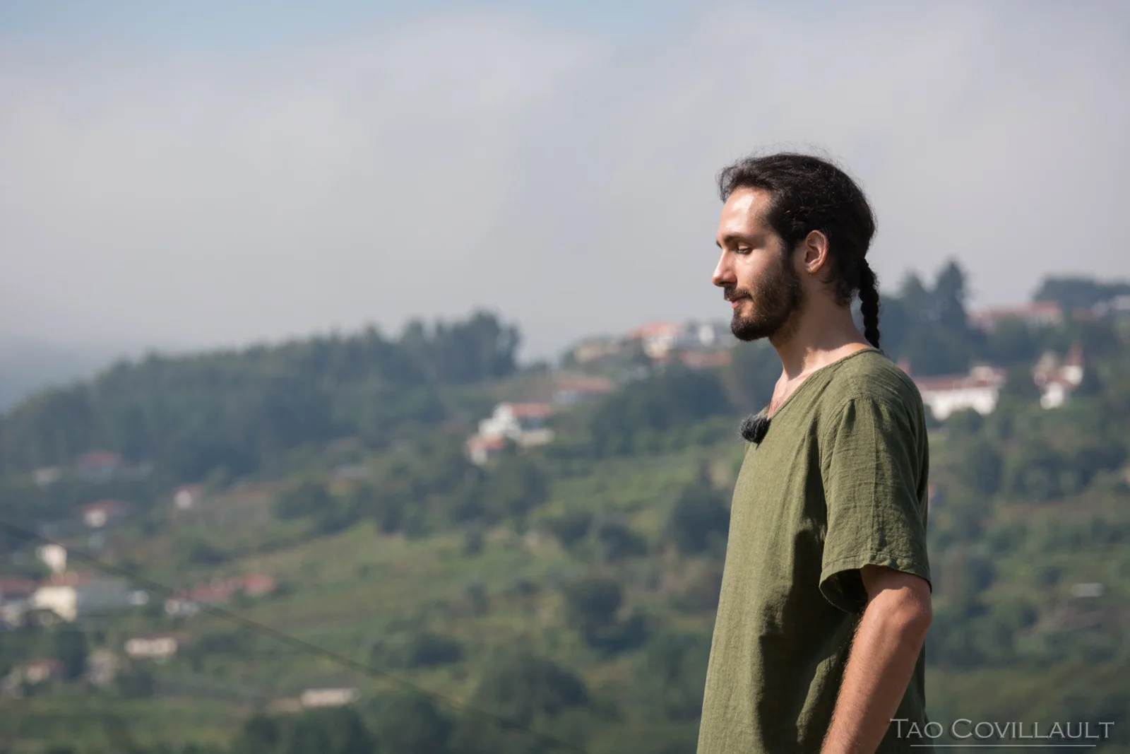 A man in a green shirt looking across a rural valley.