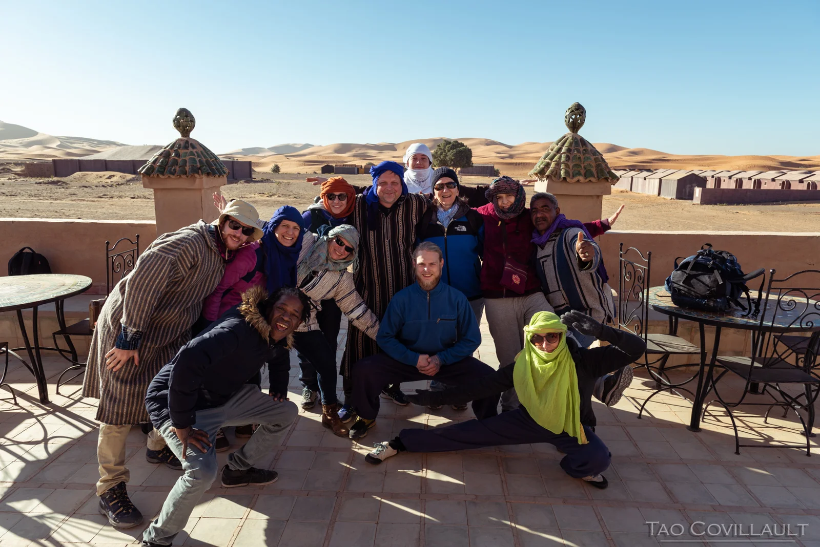 Retreat participants posing together on a terrace near sand dunes.