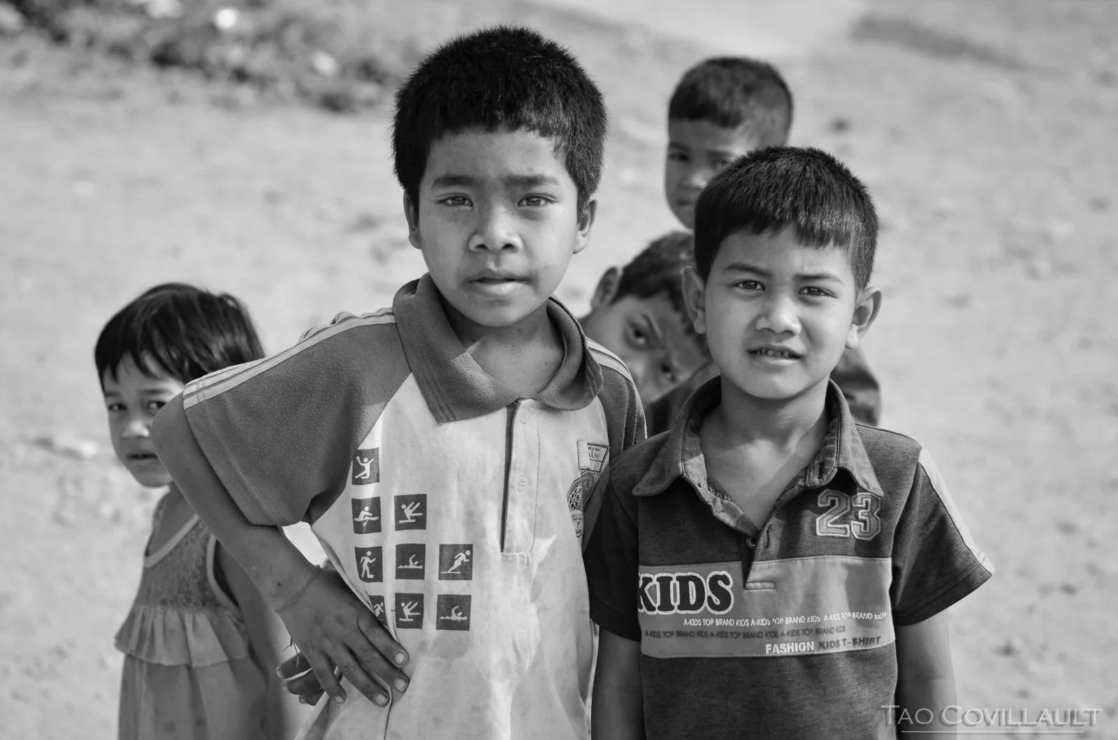 Black-and-white portrait of children gathered together outdoors.