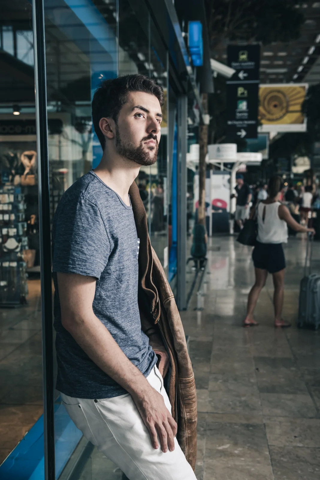 Man leaning against a doorway inside a railway station.