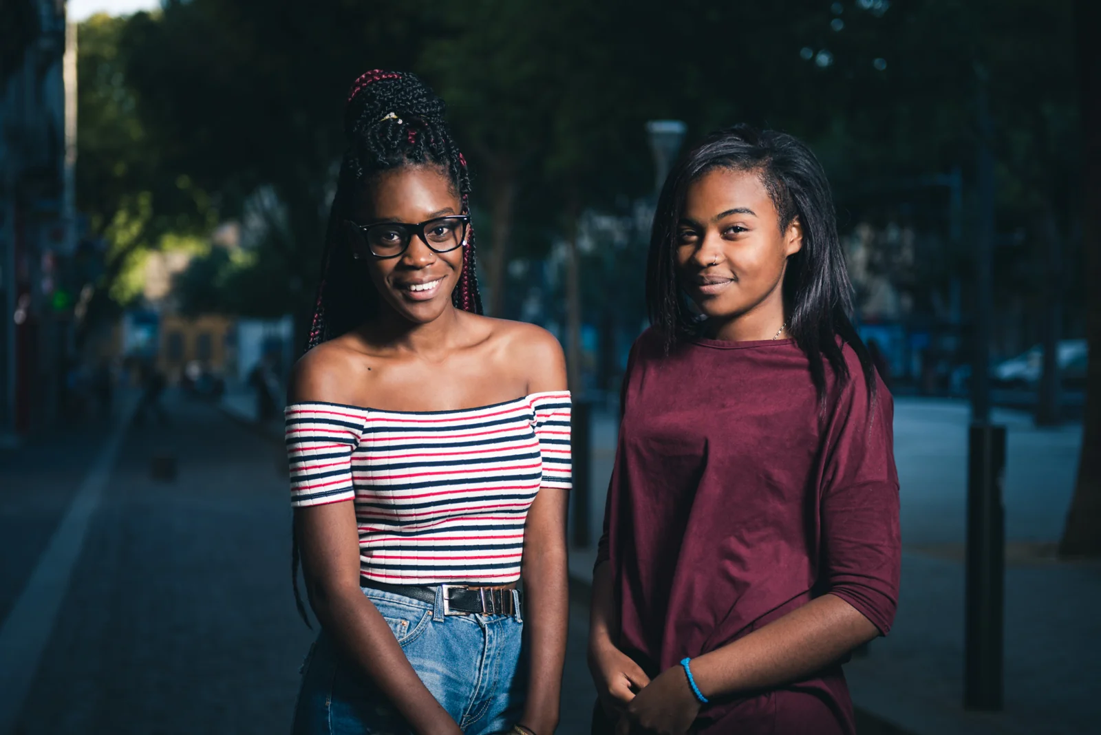 Two women standing together on a shaded Marseille street.