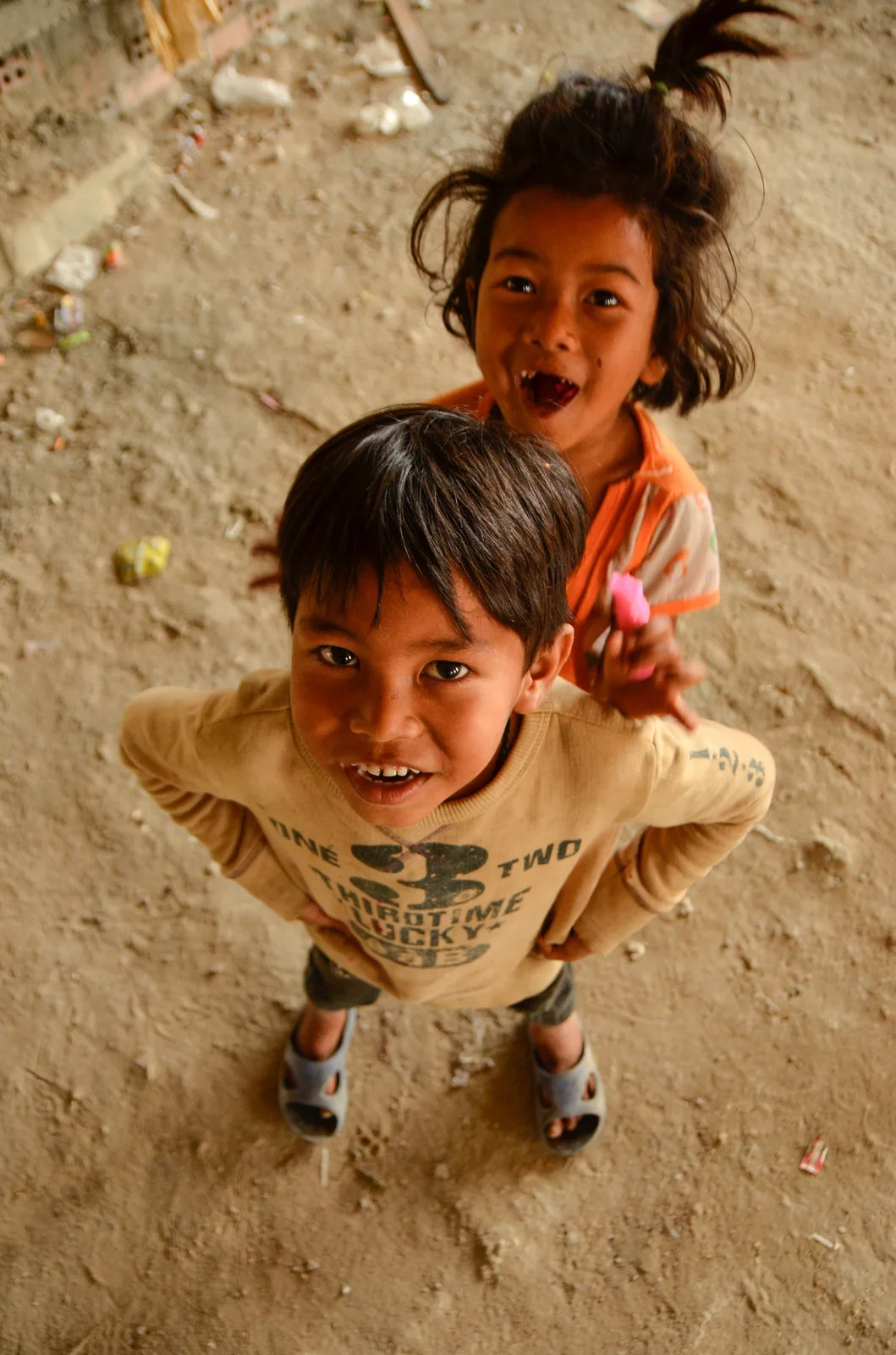 Two children looking upward from a dusty floor.