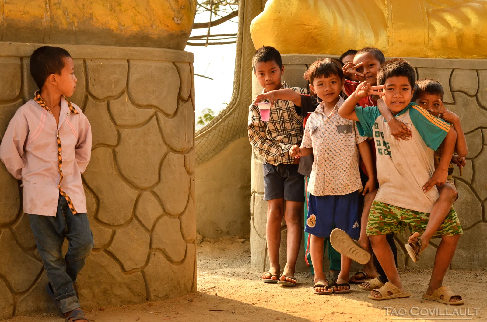 Children posing beside a painted temple column.